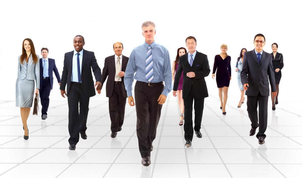 A photo of eight business people walking in formation.