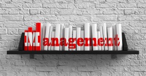 A photo of a bookshelf that spells out Management on the spines of the books