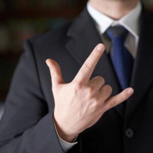 A businessman in a suit gives a hand signal