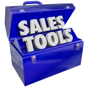 The words Sales Tools in a green metal toolbox to illustrate selling techniques, methods, schemes, plans or processes