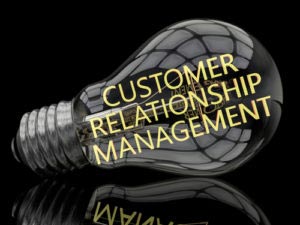 Customer Relationship Management - lightbulb on black background with text in it. 3d render illustration.