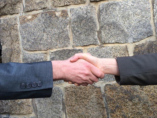 Two men shake hands that depicts how to win a negotiation