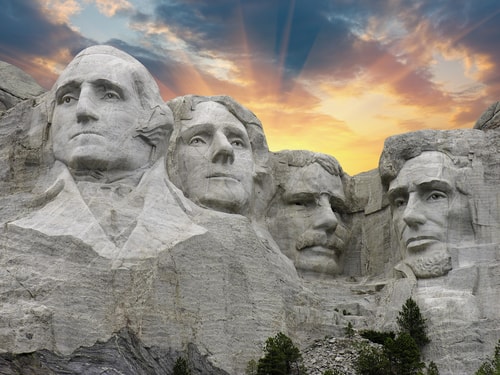 A photo of the four American Presidents carved onto Mount Rushmore depicts the 8 Traits of Successful Leaders