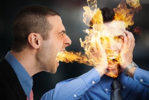 A boss breathes fire at a colleague depicting How to avoid a wrongful termination Lawsuit