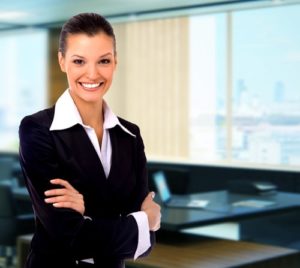 A smiling professional woman depicts what to look for when hiring a general manager