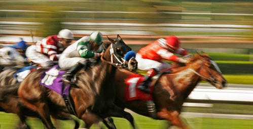 Secret Tips: How to Get More Done at Work depicted by four racehorses charge for the finish line.