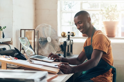 A man sits at his desk writing a blog article and this depicts reasons to write a blog