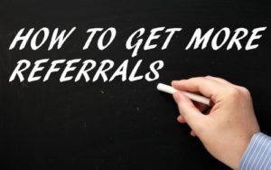 A man writes on a blackboard the phrase how to get more referrals depicting Surefire Tactics to Get More Referrals