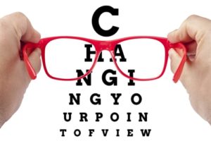 A man holds up a pair of glasses that says changing your point of view. and depicts how to Unleash Successful Change Management