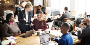 A mature female leader successfully facilitates a large staff meeting