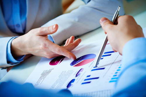 Close-up of female and male hands pointing at the business document while discussing it