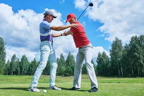 A golf instructor works with a golfer to fix ingrained habits