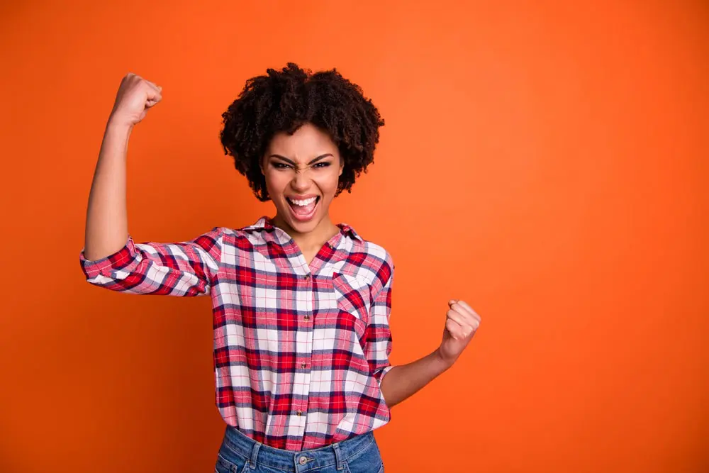 A woman pumps her fist about performance-based pay