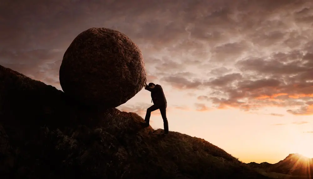 A franchisee pushing a challenging boulder up a steep hill