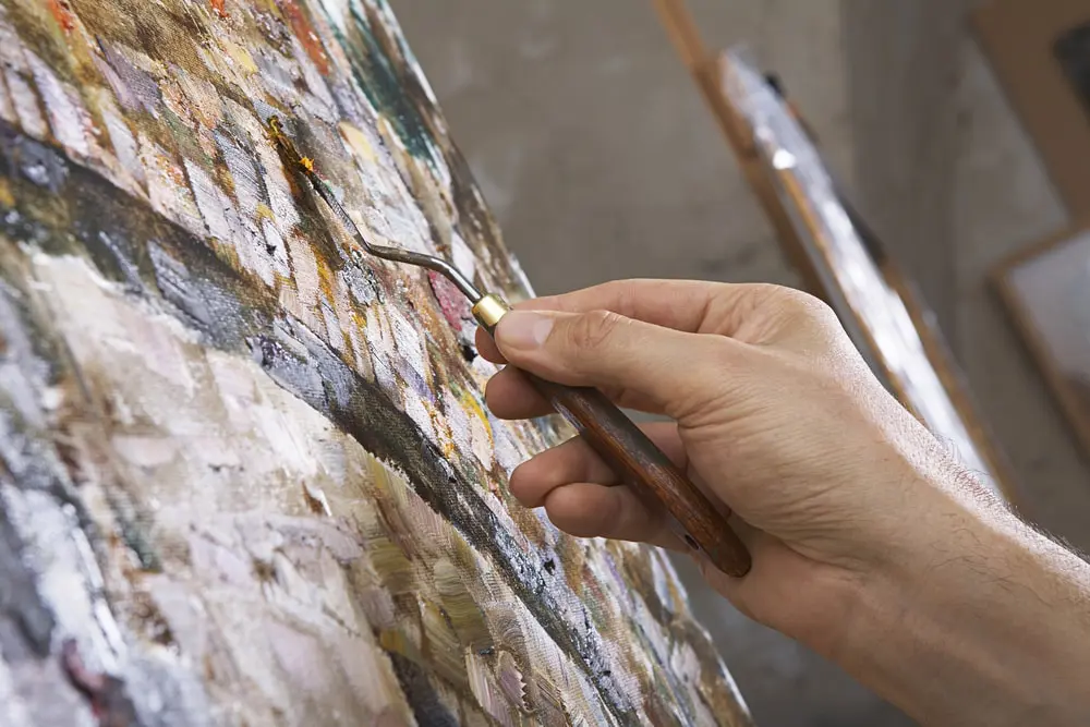 An artist applies paint to a canvas and is a metaphor for storytelling in business communication