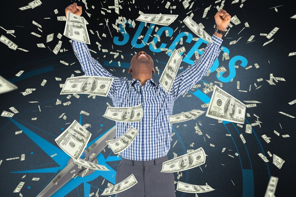 A small business owner celebrating inbound marketing success while dollar bills fly around him.