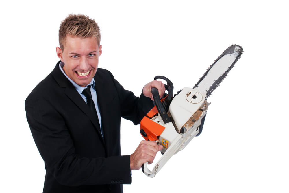 a man in a suit with a chainsaw he is cutting the cost of a bad hire