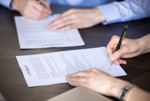 Close up view of male and female signing an operating agreement.