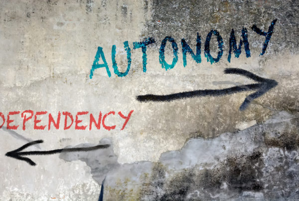 A painted wall say dependency to the left and autonomy to the right.