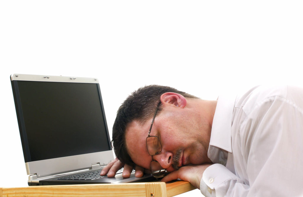 A businessman fell asleep on his laptop showing the consequences of less sleep