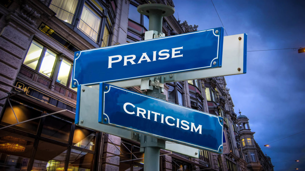 A street shows the words praise and criticism