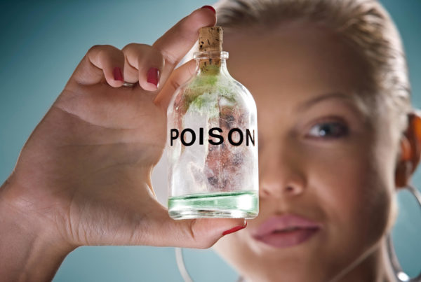 A woman holds up a bottle of toxic poison