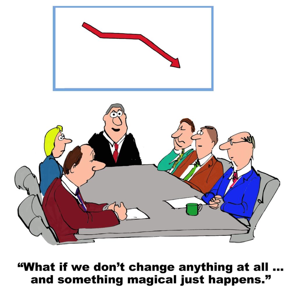 A group of executives around a conference table discuss the change with a chart behind them with a negative trend caused by organizational change