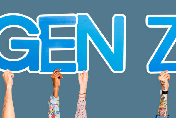 Four unique arms hold up a Gen Z sign signifying Gen Z in the workforce