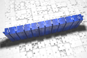 A stack of blue blocks spells the word outsourcing