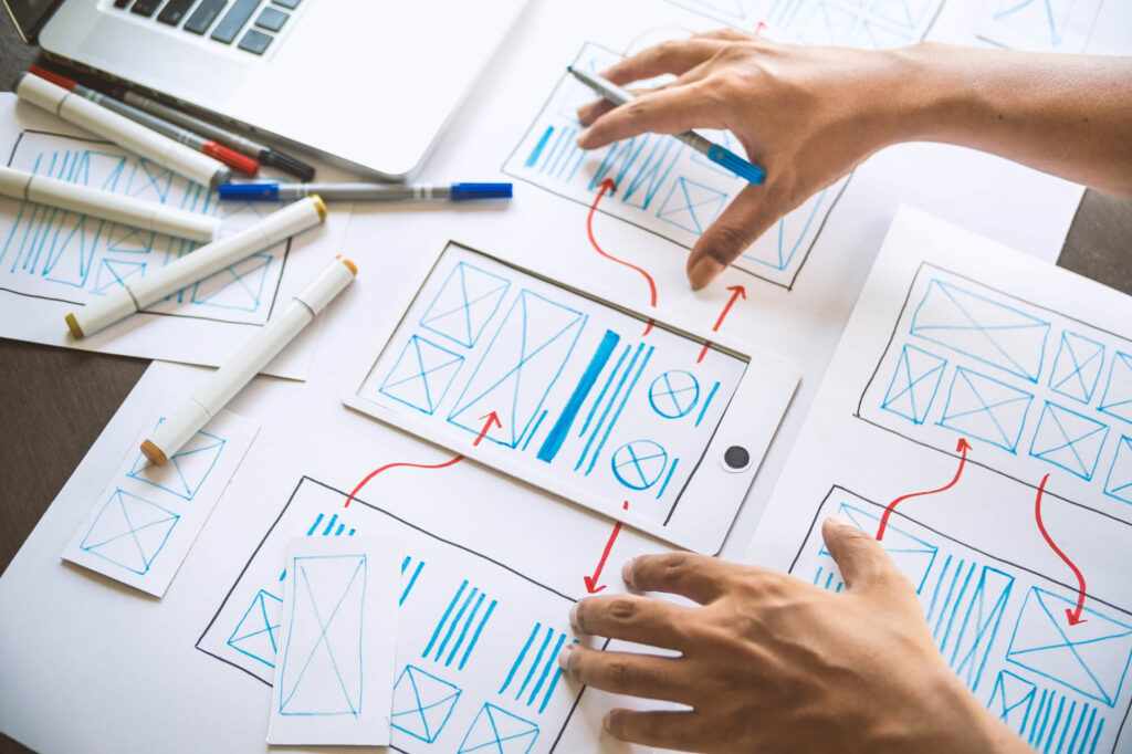 A web designer roughs out a wireframe for a website on paper.