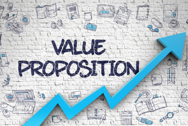 The words value proposition are written on a brick wall that contains an upward sloping graph