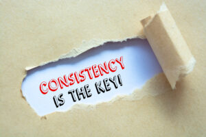 A printed card that says consistency is the key