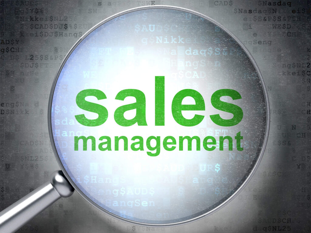 The words Sales Management are viewed through a magnifying glass