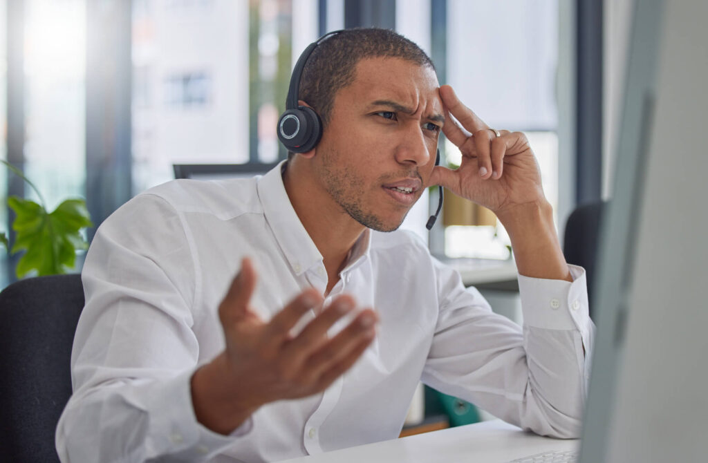 A frustrated salesman is on the phone clearly making mistakes