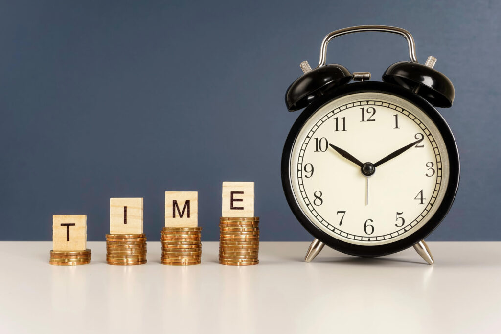 A photo of a clock and stacks of coins that spell out Time