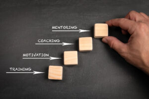 A photo of four blocks that read: training, motivation, coaching, and mentoring