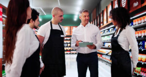 A photo of a Store Manager walking around the sales floor with his key staff members.
