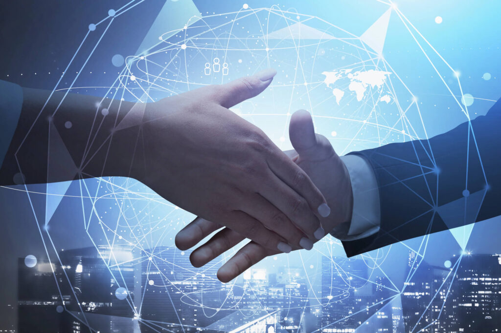 Two business people shake hands in front of an image of the globe.