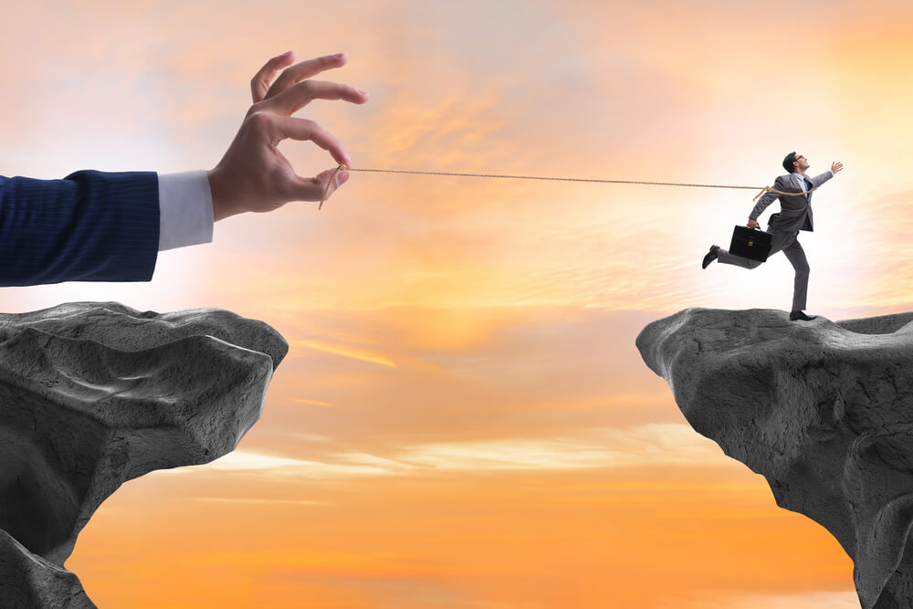 A giant hand pulls on the string that is tied to a running employee