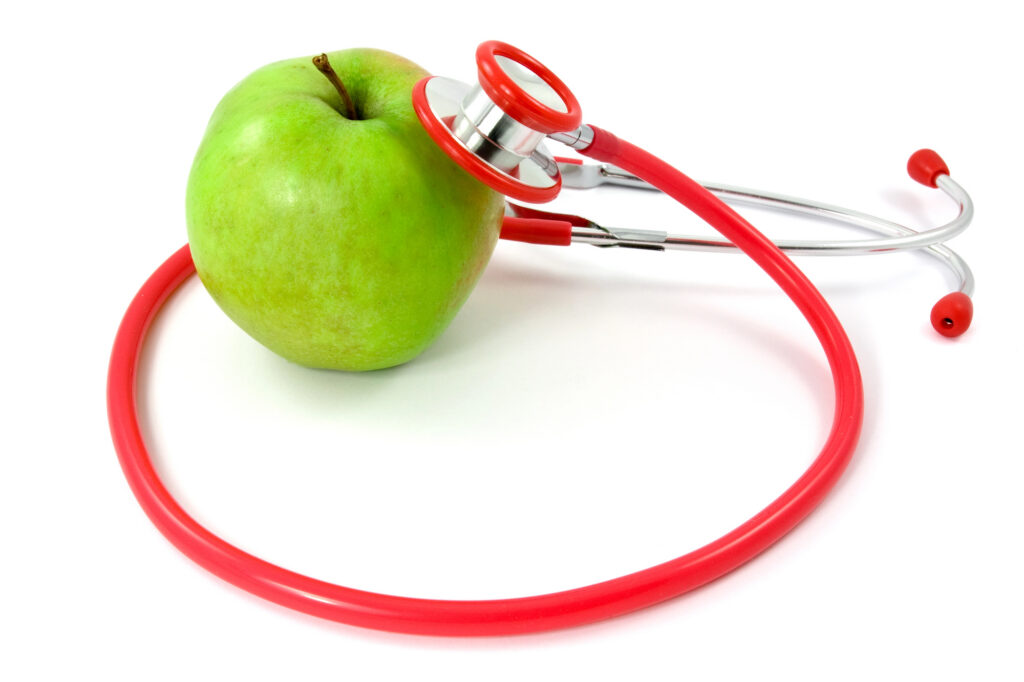 A stethoscope is on a green apple denoting an organizational check-up