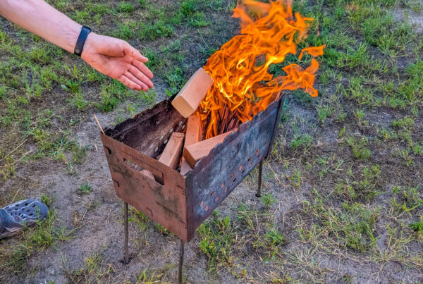 A woman feeds an outdoor fire much like a businee owner needs to feed growth