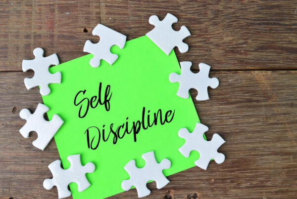 I green sign reads self discipline surrounded by an array of white puzzle pieces